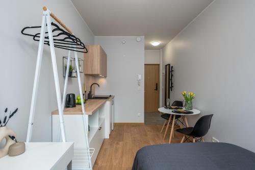 a room with a bed and a kitchen with a table at Cosy Pepleri place in Tartu