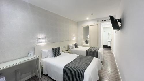 a hotel room with two beds and a television at La Boutique Puerta Osario in Córdoba
