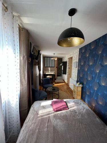 a bedroom with a bed and a blue wall at Chambre D'hôte Villa Maurice in Étretat