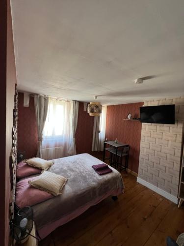 a bedroom with a bed and a tv on the wall at Chambre D'hôte Villa Maurice in Étretat