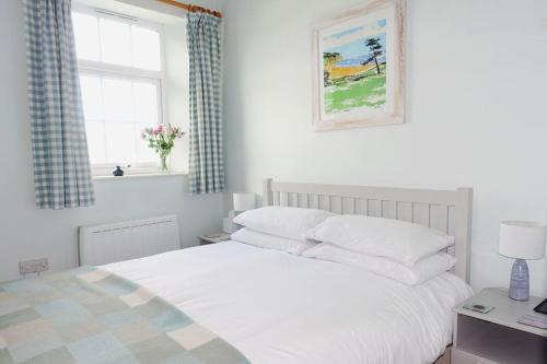 1 dormitorio con cama blanca y ventana en Shipwrights - Views across the Marina and River Dart, perfect bolthole en Kingswear