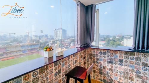 a bar with a view of a city from a window at Libré Homestay in Hanoi