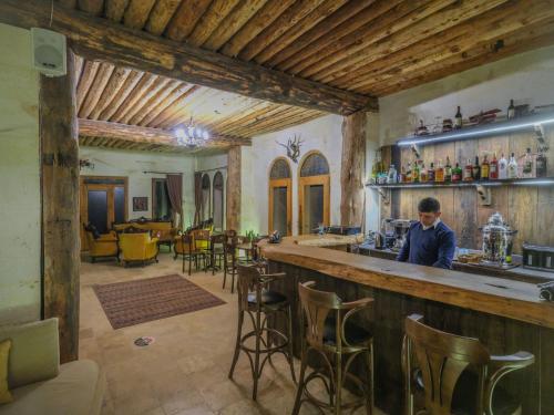 a man standing at a bar in a room at Kalsedon Cave Suites in Nevsehir