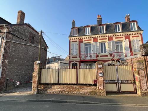 a large brick house with a gate in front of it at Chambre D'hôte Villa Maurice in Étretat