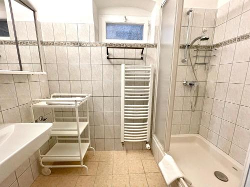 baño blanco con ducha y lavamanos en Apartment zum Schlossberg - Top 1 self check-in, en Graz