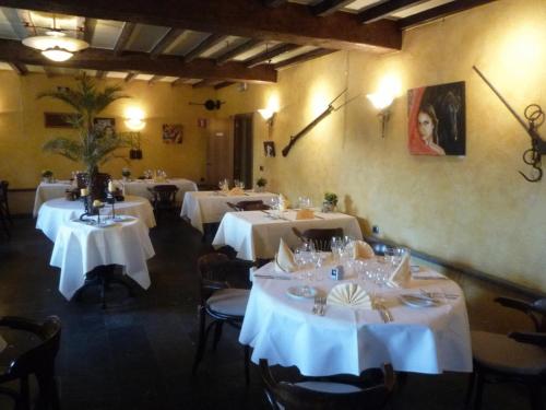 uma sala de jantar com mesas e toalhas de mesa brancas em Le Château de Rendeux em Rendeux