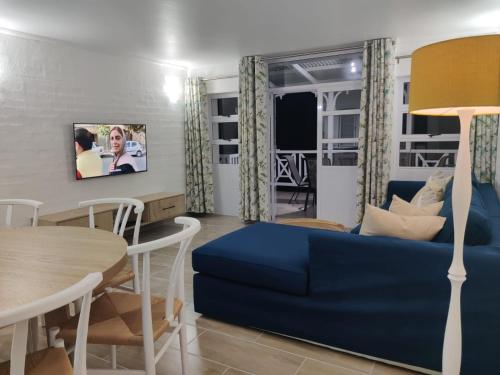 a living room with a blue couch and a table at 44 Montego Bay Caribbean Estates in Port Edward