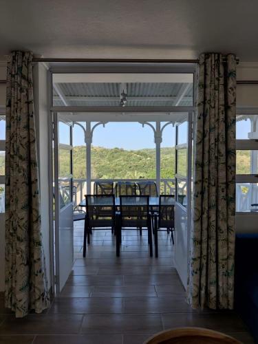 a dining room with a table and chairs on a balcony at 44 Montego Bay Caribbean Estates in Port Edward