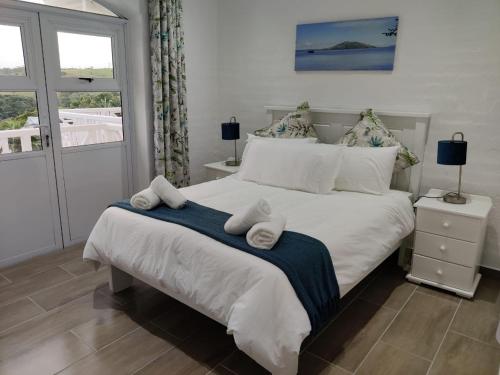 a bedroom with a large bed with towels on it at 44 Montego Bay Caribbean Estates in Port Edward