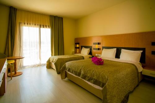 a hotel room with two beds and a window at Hotel Sempati in Kérynia