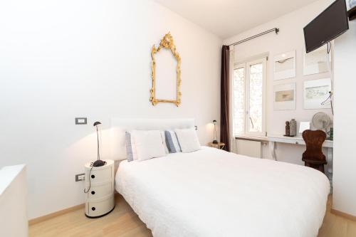 a white bedroom with a white bed and a window at Gastaldaga in Cividale del Friuli