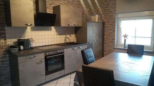 a kitchen with a counter and a table with chairs at Ferienwohnung Naturblick in Schönhagen