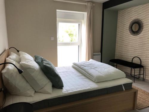 a bedroom with a bed with pillows and a window at Les 4 gites de la Saisse in Pont-de-Poitte