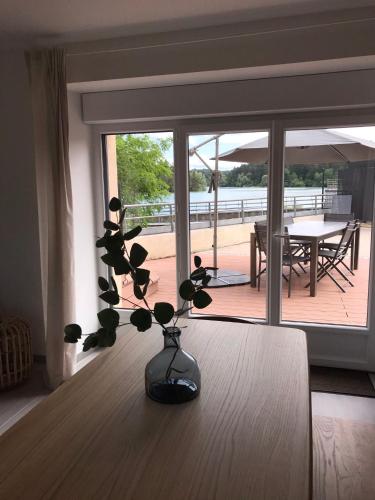 a vase sitting on a table in front of a window at Les 4 gites de la Saisse in Pont-de-Poitte