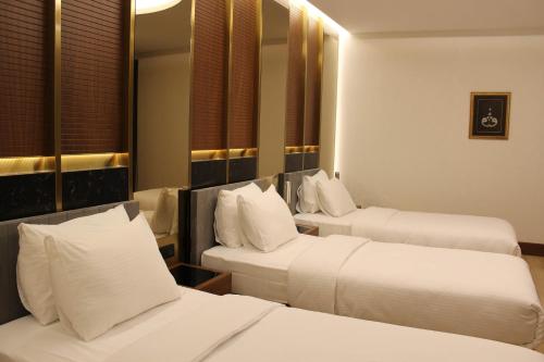 a hotel room with two beds and a mirror at Henna Hotel Istanbul in Istanbul