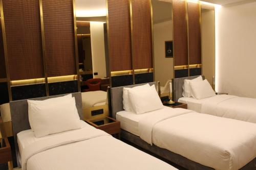 a room with three beds with white pillows at Henna Hotel Istanbul in Istanbul