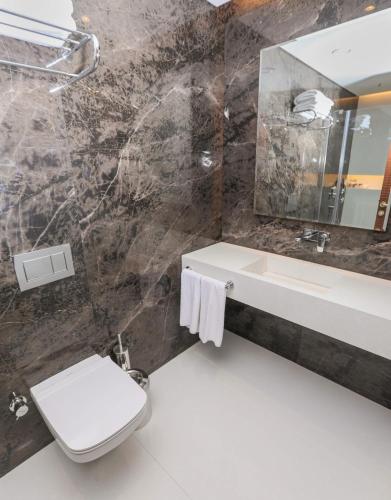 a bathroom with a sink and a toilet and a mirror at Henna Hotel Istanbul in Istanbul