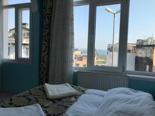 a bed sitting in front of a window with a view of the ocean at Tulip Guesthouse in Istanbul