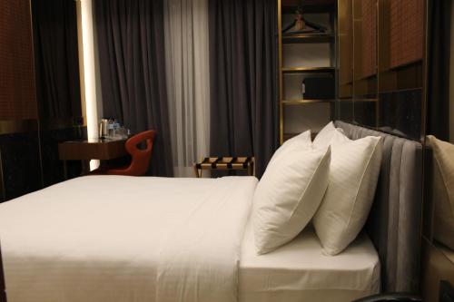 a bed with white pillows in a hotel room at Henna Hotel Istanbul in Istanbul