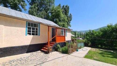 een huis met een oranje deur en een hek bij Beekeeper's Hause in Arslanbob