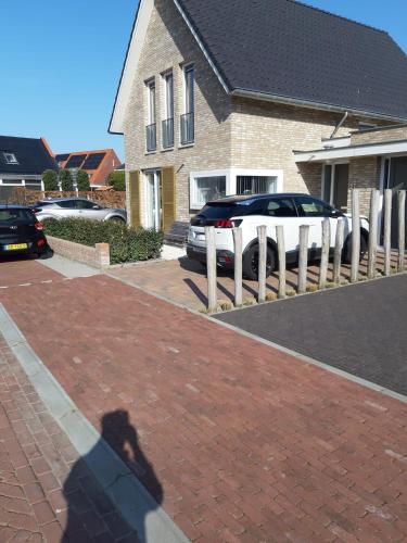a shadow of a person taking a picture of a car at Room by the sea in Zoutelande