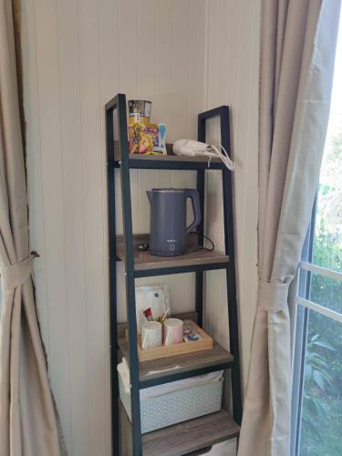 a shelf with a pot on it next to a window at Morinaka Craftfe & Poshtel in Ban Na Muang