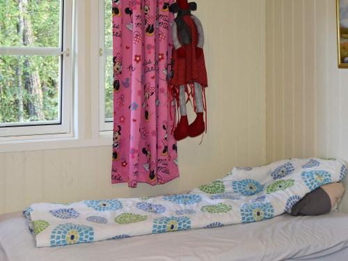 a bedroom with a bed and a window with clothes at 6 person holiday home in SANDANE-By Traum in Sandane