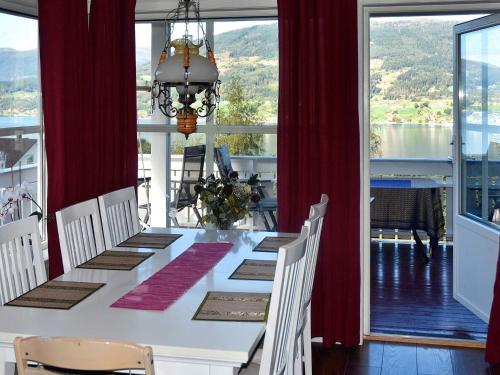 a dining room with a white table and red curtains at 6 person holiday home in SANDANE-By Traum in Sandane
