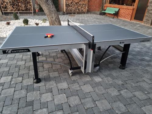 a ping pong table sitting on a brick patio at Apartament TANGO la casa PIANO HOUSE ,cu parcare in Alba Iulia