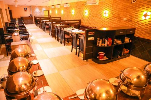 a dining room with tables and chairs in a restaurant at Hotel Mary Land Velankanni in Velānganni