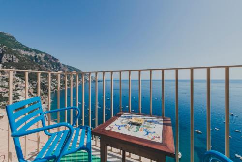 a table and two chairs on a balcony overlooking the ocean at Villa Nettuno in Positano