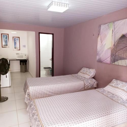 a bedroom with two beds and a bathroom at Isa Natal 3 Banheiro Privativo in Natal