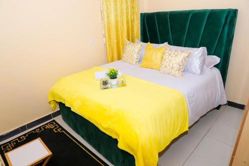 a bedroom with a bed with a yellow blanket at The Ivy Suite- one bedroom 3 mins away from Ruiru Rainbow Resort in Ruiru