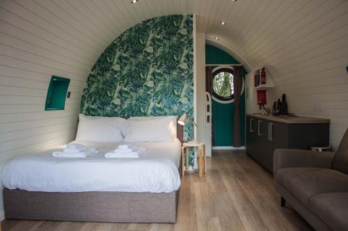 a bedroom with a bed with a green wall at High Oaks Grange - Glamping in Pickering