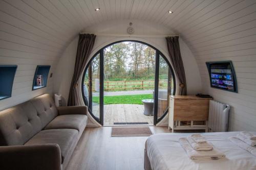 Habitación con cama, sofá y ventana en High Oaks Grange - Glamping en Pickering