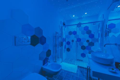 a blue bathroom with a toilet and a sink at Villa Nettuno in Positano