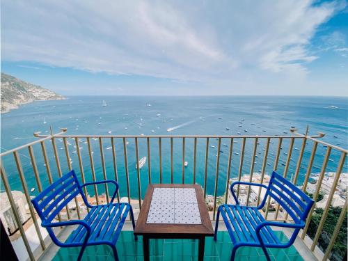 two chairs and a table on a balcony with the ocean at Villa Nettuno in Positano