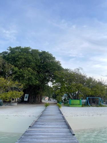 a wooden walkway on the beach with a playground at Atholhu Residence in Fehendhoo