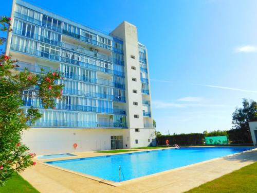 un gran edificio con una piscina frente a él en GMID IMMO Estudio Ed La Masia, en Roses