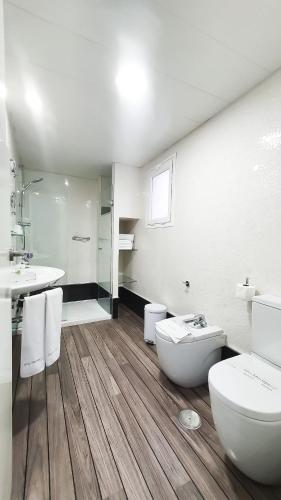 a white bathroom with a toilet and a sink at La Boutique Puerta Osario in Córdoba