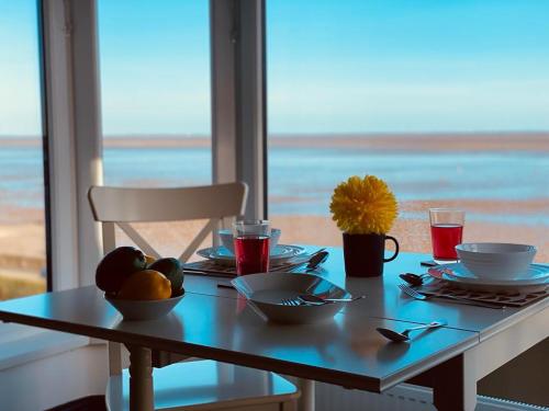 a table with food on it with a view of the ocean at TYME Coastal Retreats - 1 and 2 Bedroom in Cleethorpes