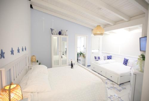 a white room with a bed and a couch at BLU MARE suite privata & apartment in Terrasini
