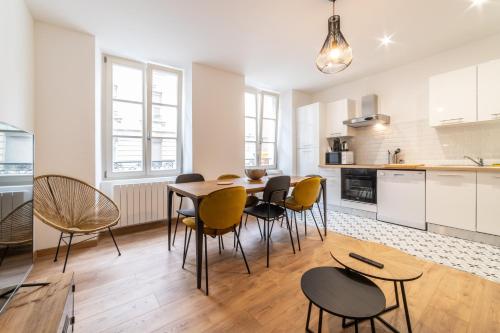une cuisine et une salle à manger avec une table et des chaises dans l'établissement Le convivial, appartement Centre ville Mulhouse, à Mulhouse