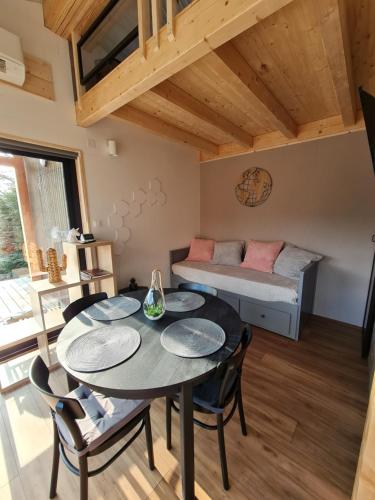um quarto com uma mesa e cadeiras e um sofá em Bienvenue dans la COSY BOX, micro maison agréable em Wittisheim