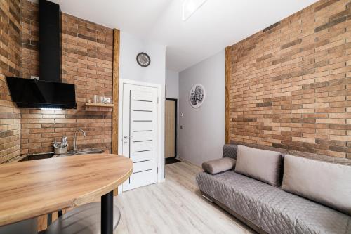 a living room with a couch and a brick wall at Затишні смарт-квартири в історичному центрі! in Uzhhorod