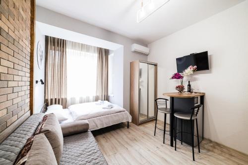 a hotel room with a bed and a table at Затишні смарт-квартири в історичному центрі! in Uzhhorod