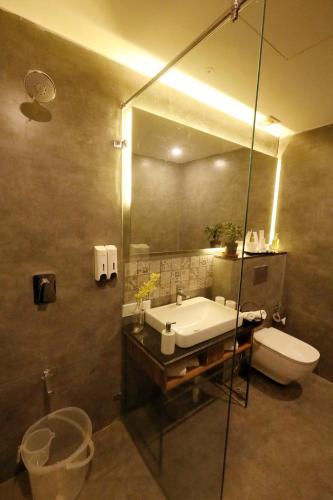 a bathroom with a sink and a toilet and a mirror at Destiny - The Farm Resort in Ooty