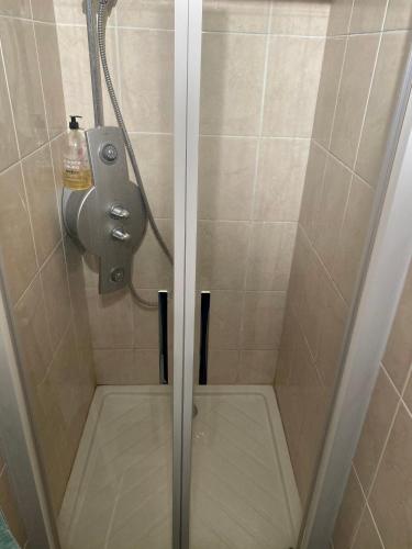 une douche avec une porte vitrée dans une salle de bain dans l'établissement Appartement de prestige vue mer place de parking, à Le Touquet-Paris-Plage