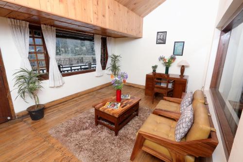 a living room with a couch and a table at Destiny - The Farm Resort in Ooty