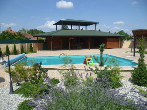 a swimming pool in a yard with a house at Margaréta Penzión in Veľký Meder